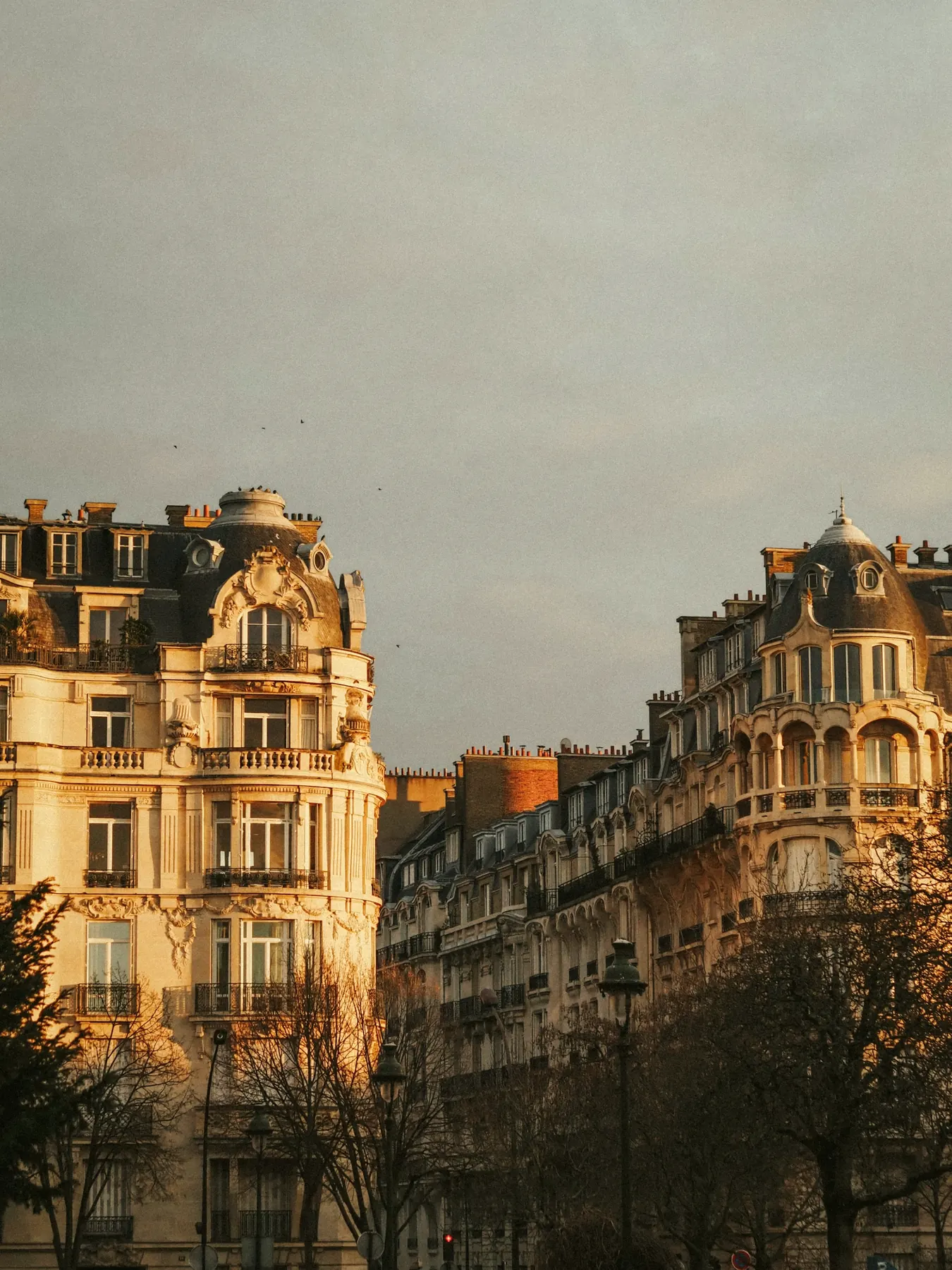 Façades haussmanniennes ouvragées dans la lumière du soir